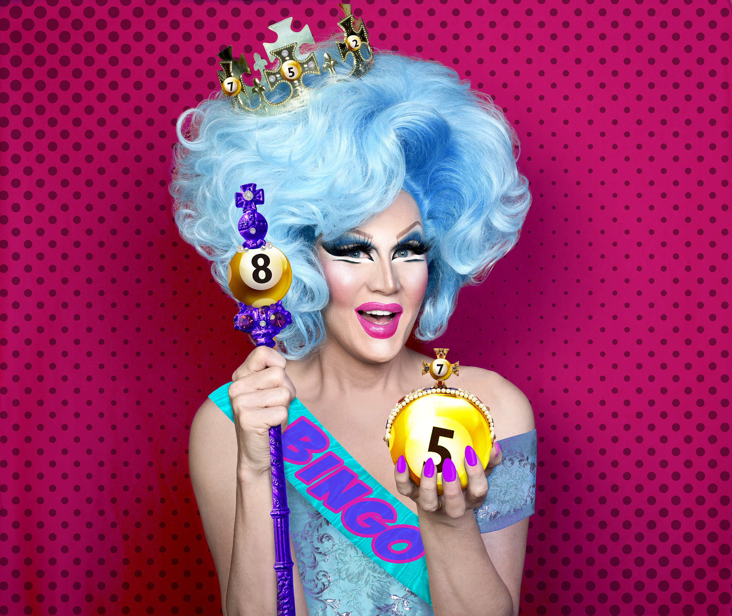 a drag queen with blue curly hair wearing a sash saying "bingo"