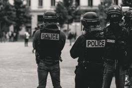 Photo by ev on Unsplash, black and white photo of police officers in riot gear
