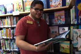 Miguel Romero looks through Westwood location's children's book collection.