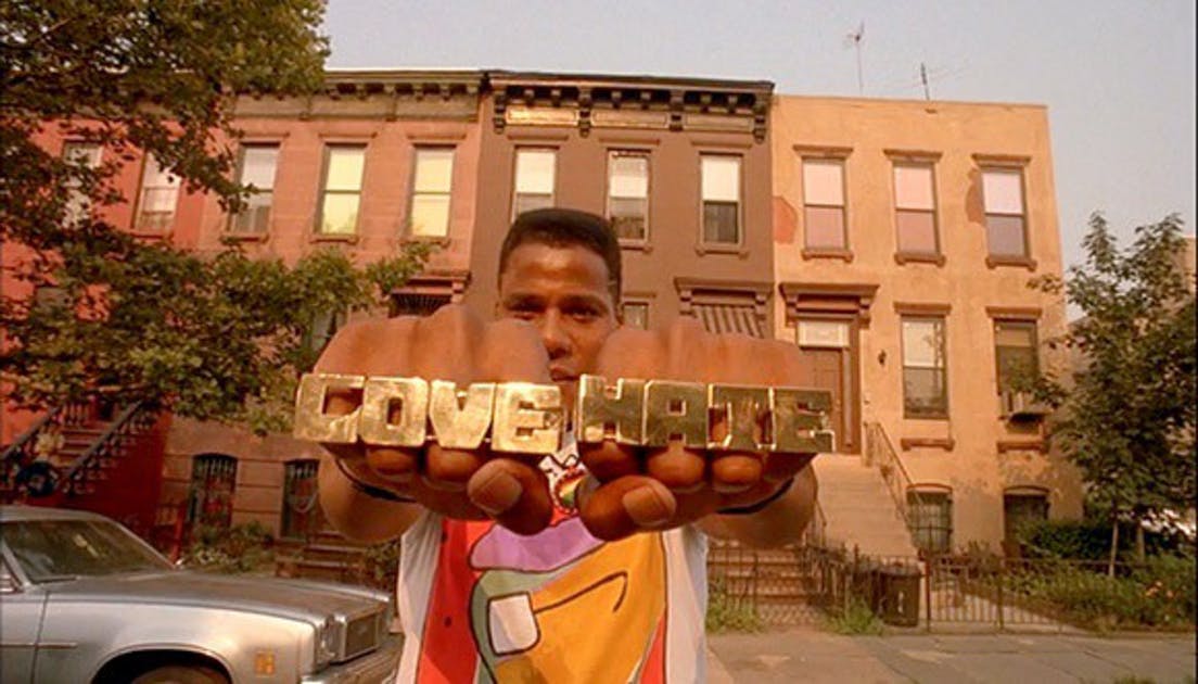 Scene from Do the Right Thing with man wearing rings that say love and hate