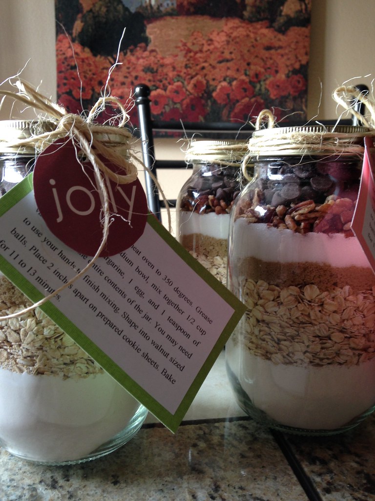 two jars with layered cookie ingredients and decorative tag