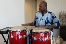 Bob Hall wearing a blue shirt playing red drums
