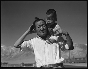 Photo of Manzanar Relocation Center, CA. Grandfather and grandson of Japanese ancestry at War Relocation Authority center.