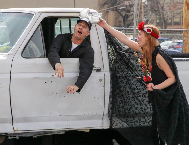 Actors in a parking lot, one in a white pickup truck
