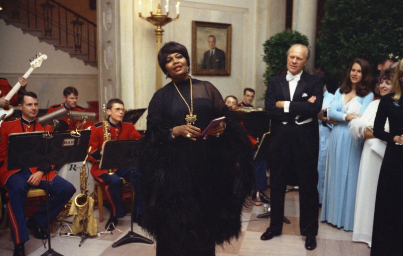 Photograph of President Gerald R. Ford Watching Pearl Bailey Sing during an Impromptu Performance After a State Dinner Honoring the Shah of Iran