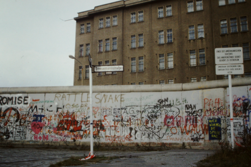 Graffitied Berlin Wall with a Large Building Looming in the Background