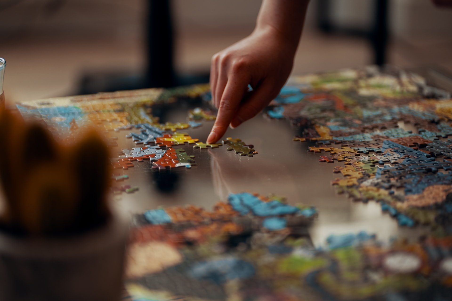 Photo of someone solving a jigsaw puzzle (from Unsplash)