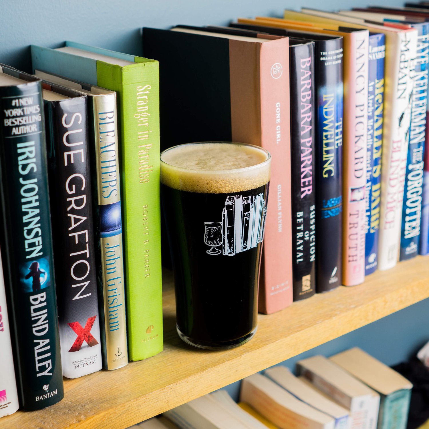 a glass of beer from Fiction on a bookshelf
