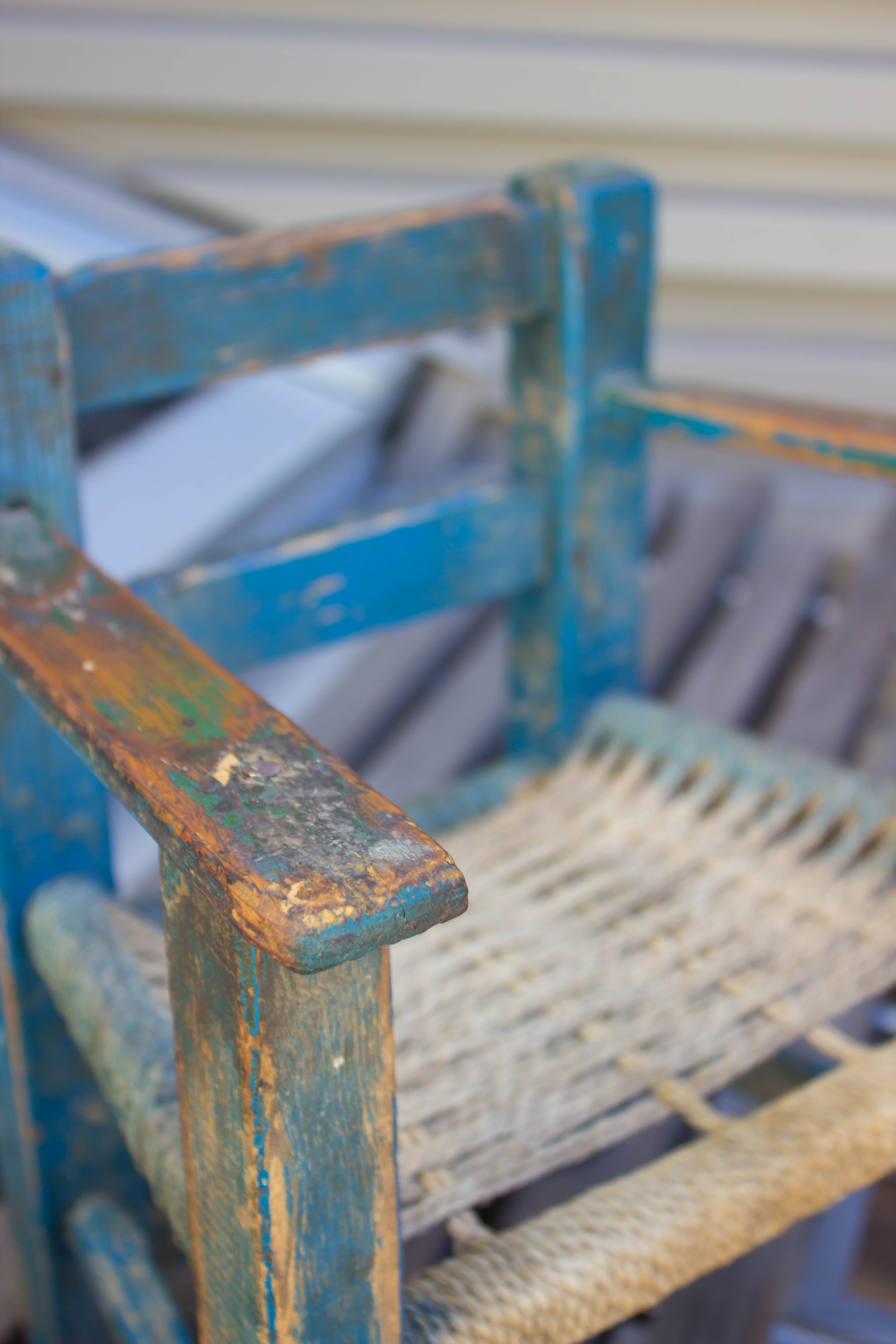 A small blue weathered child-sized wooden chair