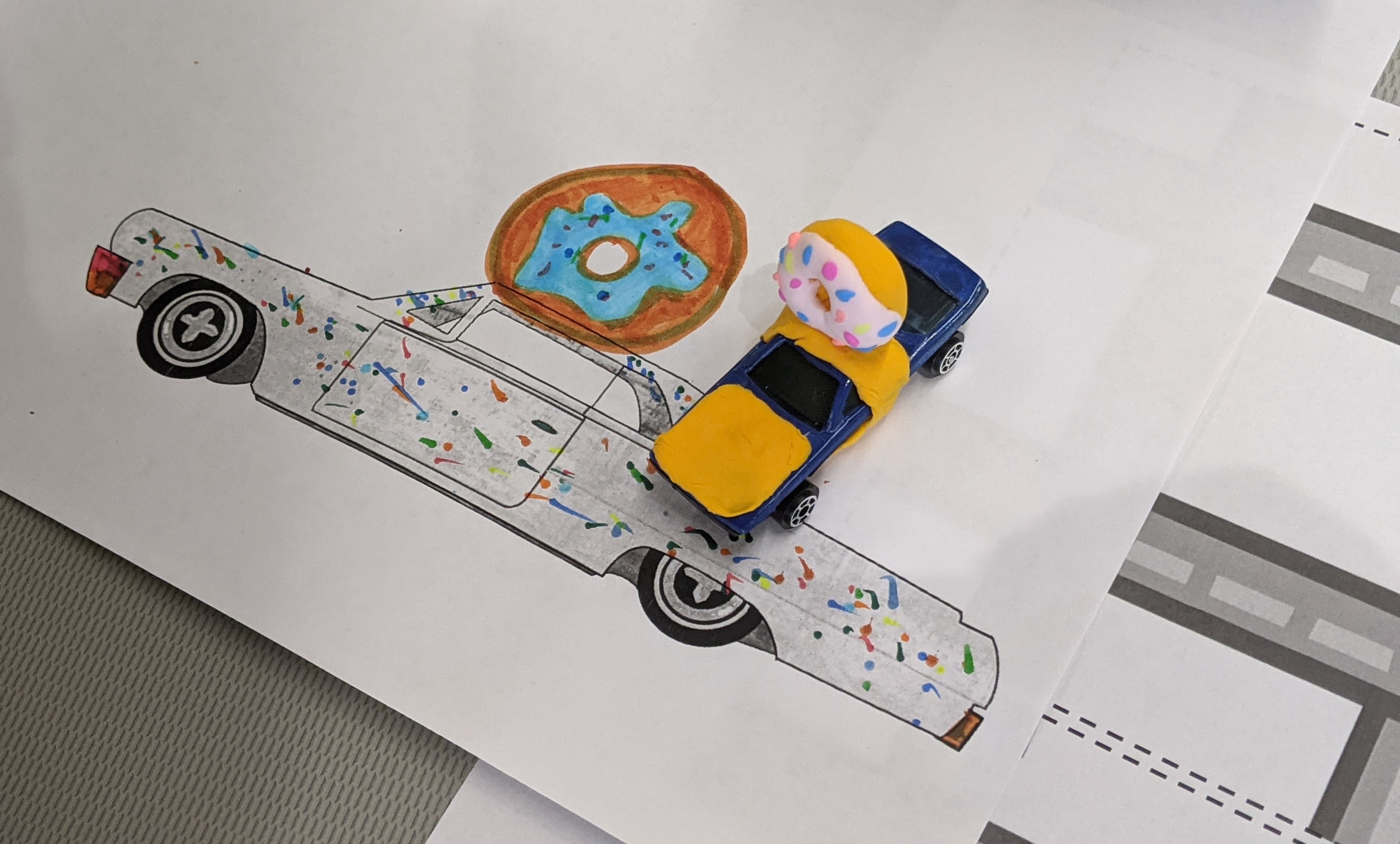 Drawing of a artistic car with a toy car decorated to look like the design.