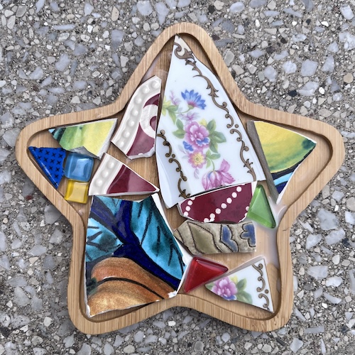 Colorful star-shaped artwork made of broken shards of pottery