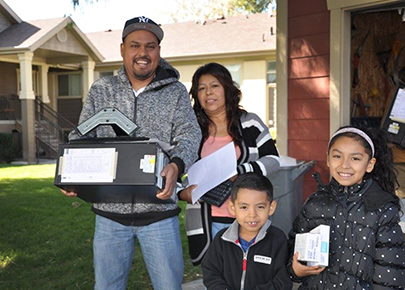 A family holds technology and smiles