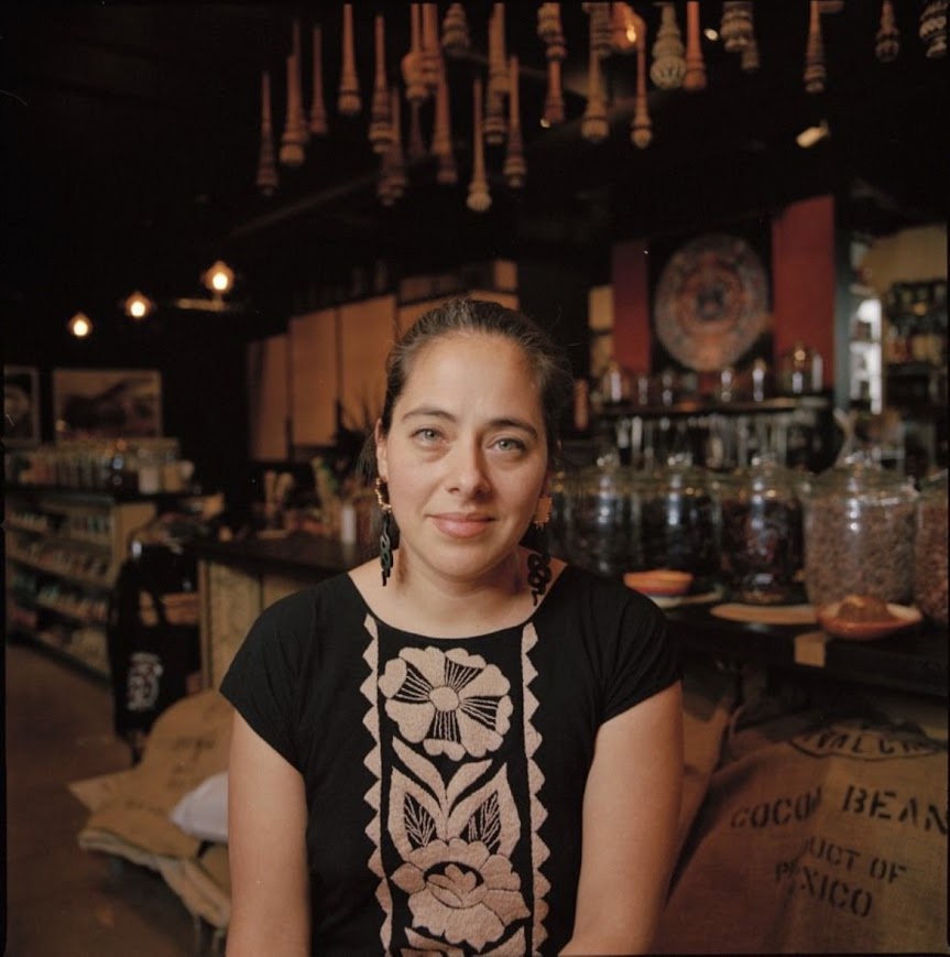 Damaris smiling at her cafe. 