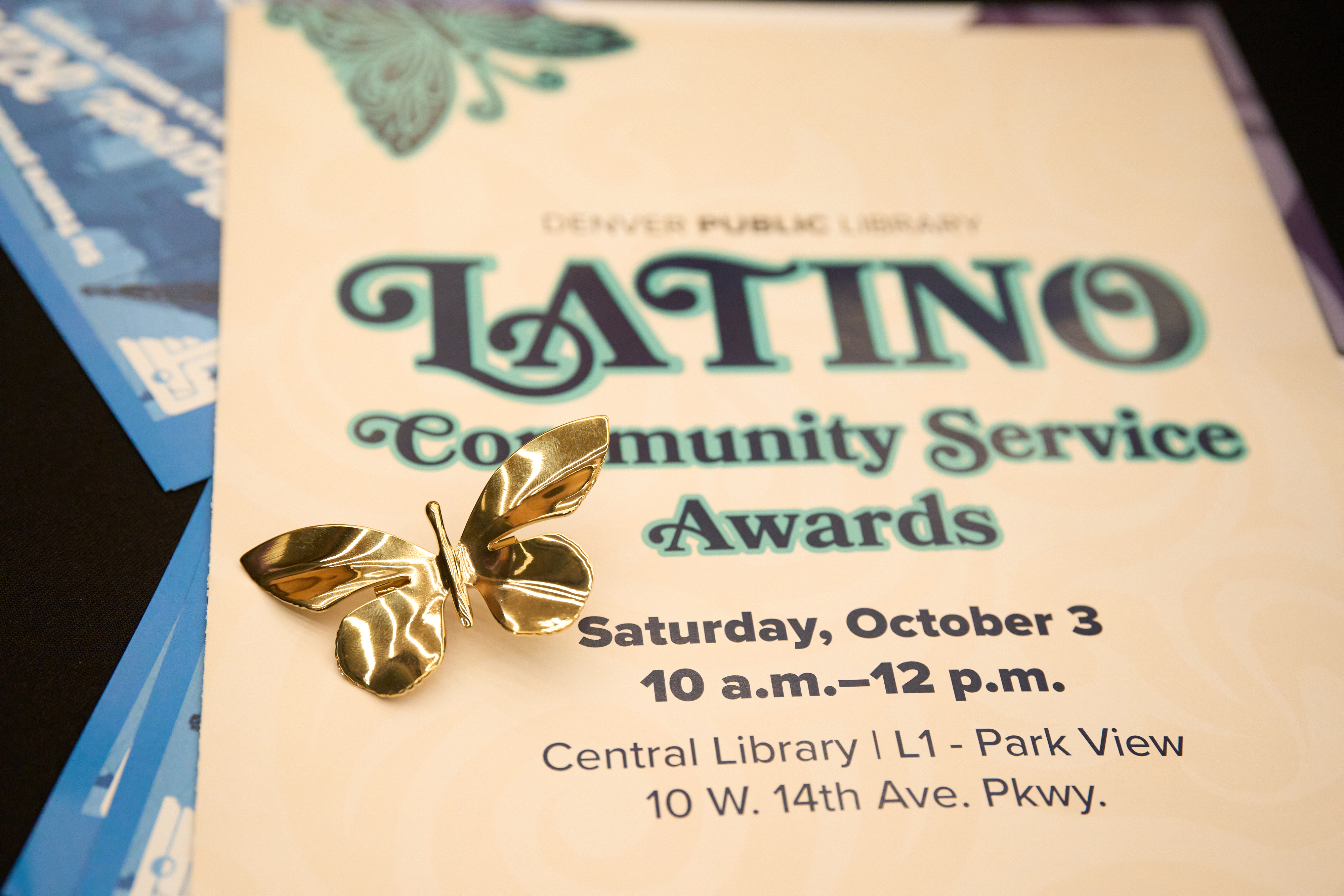 Event program with a gold butterfly pin on top.