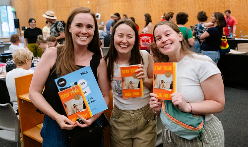 Three people smiling and holding books at a Library Lineup event