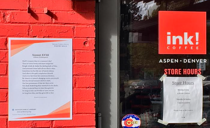 White poster containing poem posted on a red wall outside of Ink Coffee shop