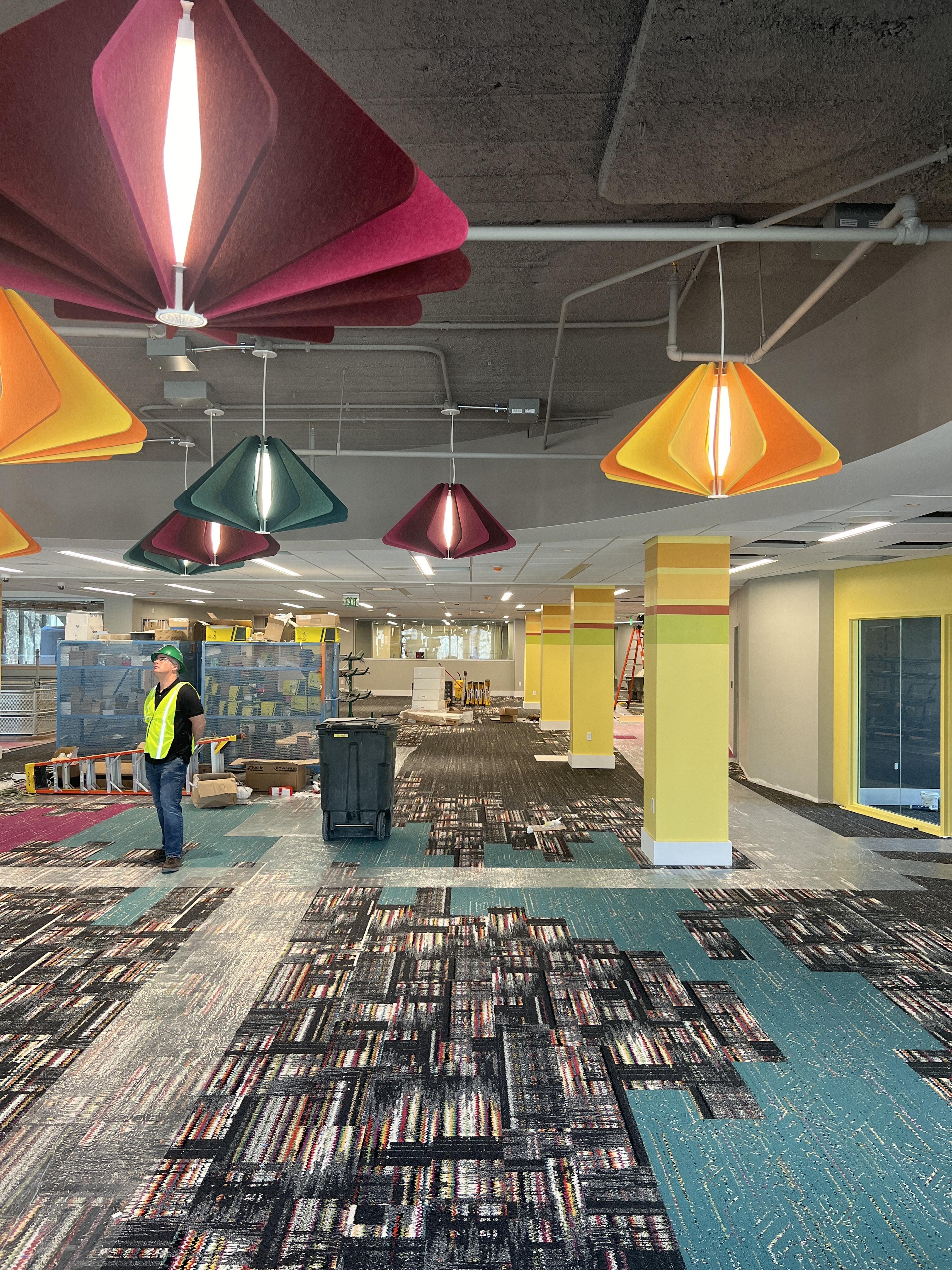 Picture of the new Teen Library at the Central Library. The picture features colorful carpets and felt light fixtures.