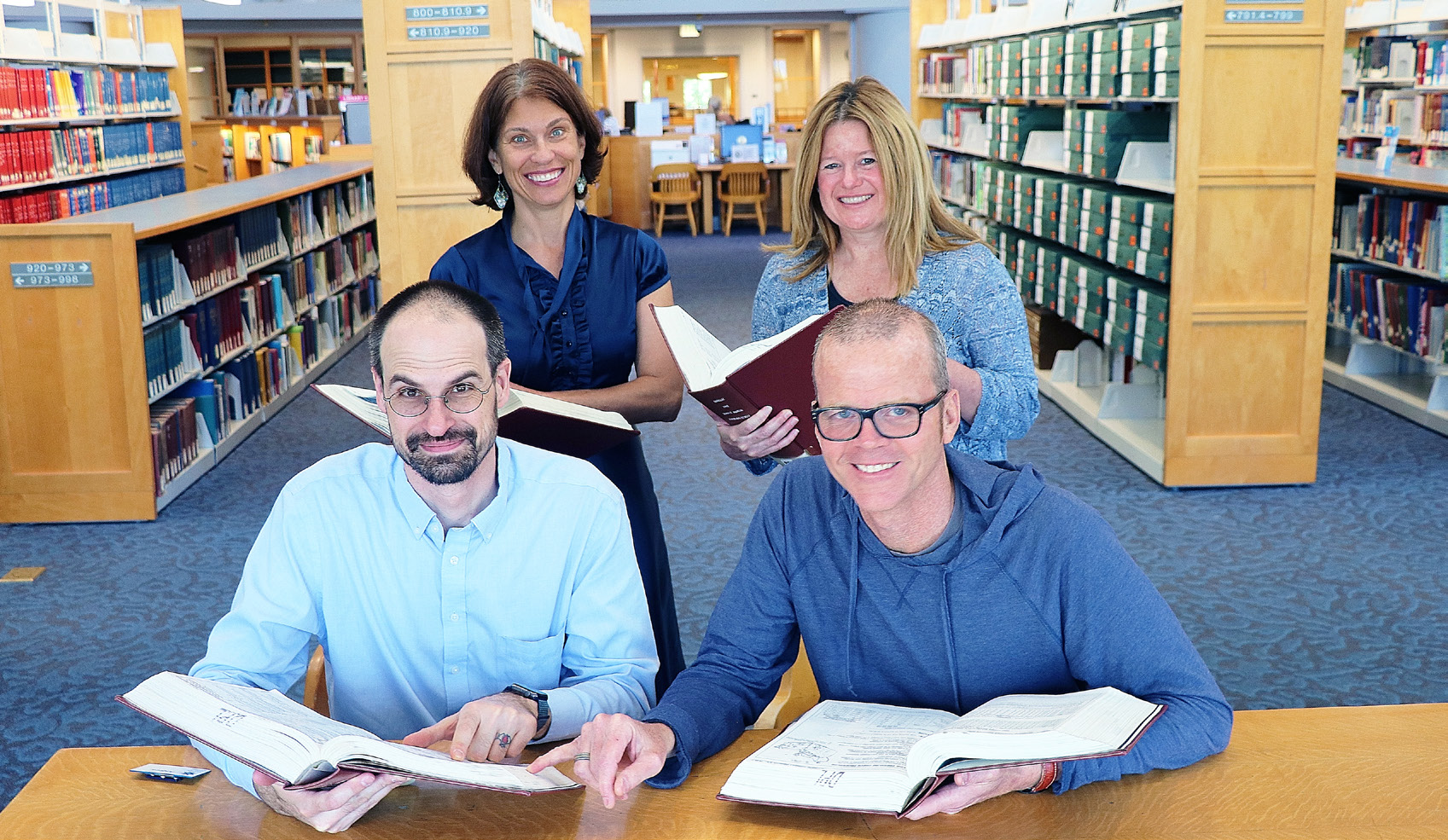 Reference librarians at DPL holding text books 