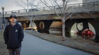Casey Kawaguchi standing in front of his art in Cherry Creek