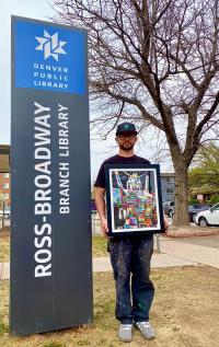 AGPNT holds a piece of his artwork outside the Ross-Broadway Branch Library
