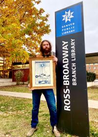Oak Bloak holds a piece of his artwork outside the Ross-Broadway Branch Library
