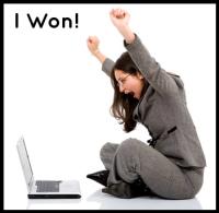 Woman in gray suit sitting at laptop raises hands over head, with words "I won!" above