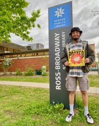 Akubis holds a piece of his artwork outside the Ross-Broadway Branch Library