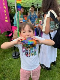 A young child eating a rainbow pastry