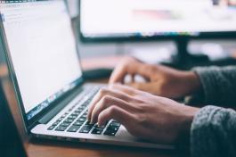 Hands typing at a laptop computer 