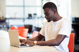 Man working on a laptop while in the Community Technology Center