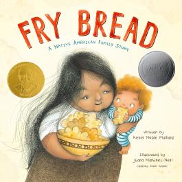 Fry Bread book cover with an adult holding a big bowl of fry bread and a baby