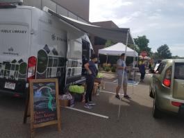 Two staff members help a customer from the Bookmobile