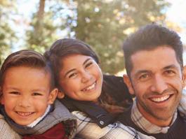 A man and two children smile at the camera