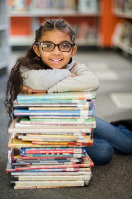 Girl leaning on a pile of books