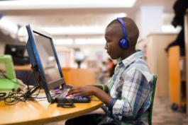 Child with headphones using computer 