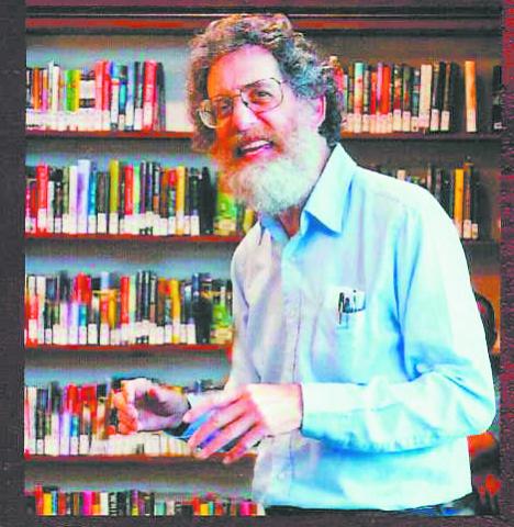 Phil Goodstein stands in front of a shelf of books at the Park Hill Branch Library