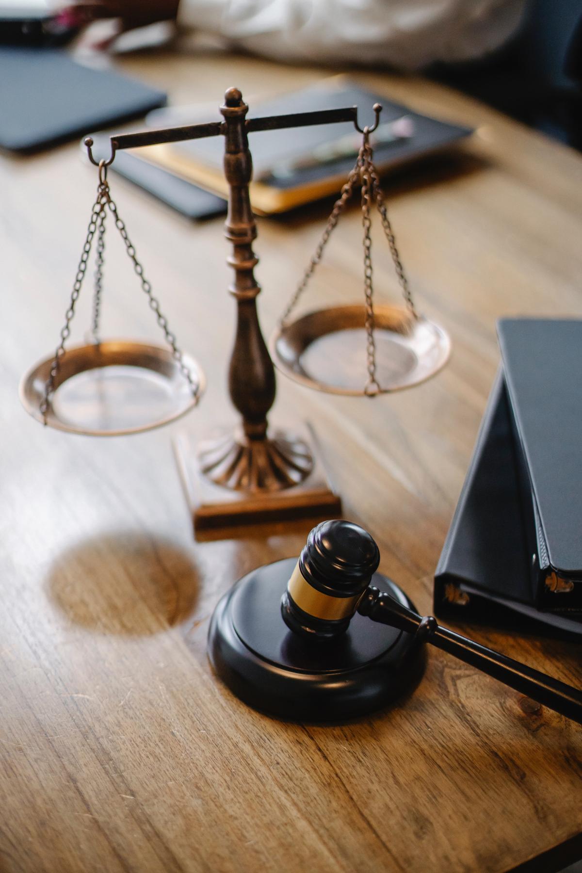 A wood desk with gavel and justice scales