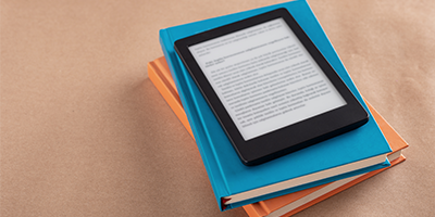 Colorful stacked books and kindle