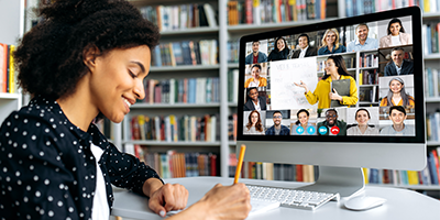 Teacher conducts online lecture, female student takes notes