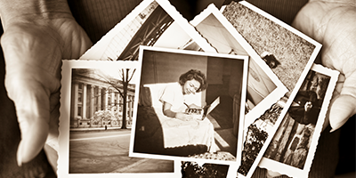 Elderly woman holding a collection of old photographs