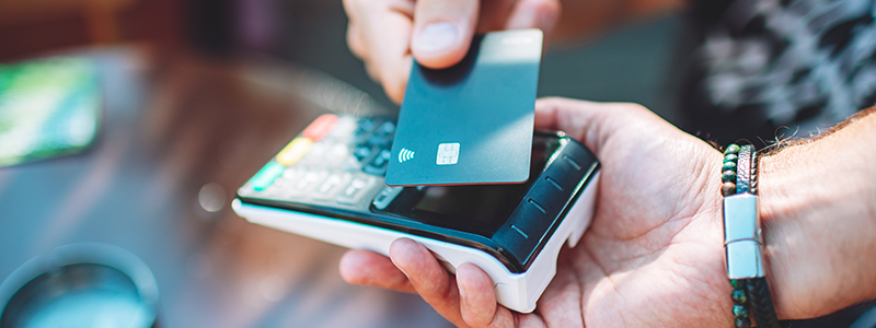 Close-up of hands with credit card and credit card reader