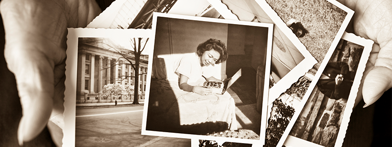A collection of old sepia toned photographs held in hands