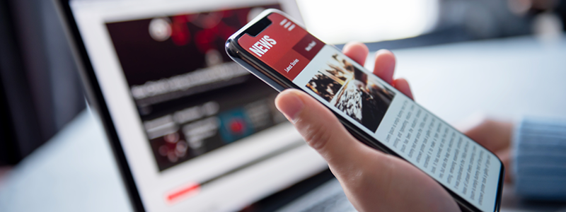 Online news on a smartphone and laptop