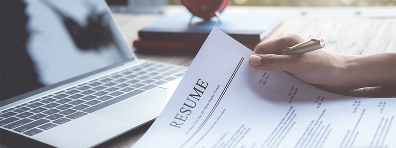 Business man reviews his resume on desk