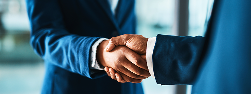 Cropped shot of two businesspeople shaking hands in a modern office