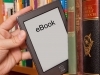 eReader being pulled out of bookshelf